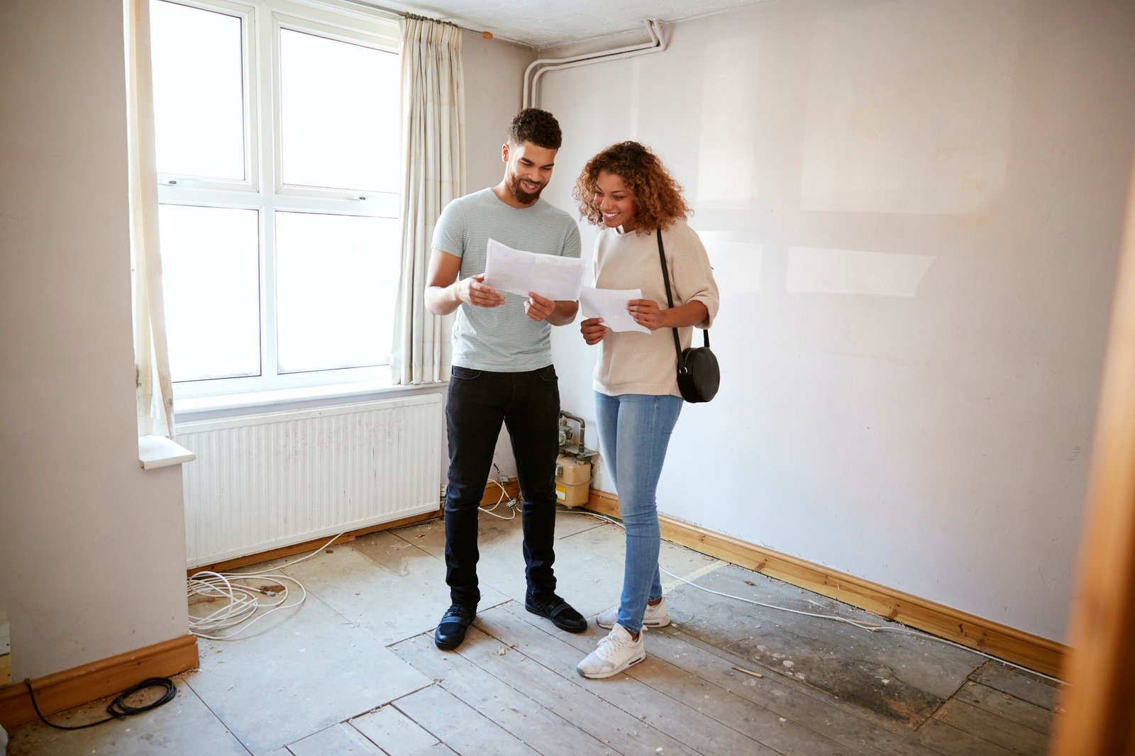 couple-buying-house-for-first-time-looking-at-house-survey-in-room-to-be-renovated-1.jpg